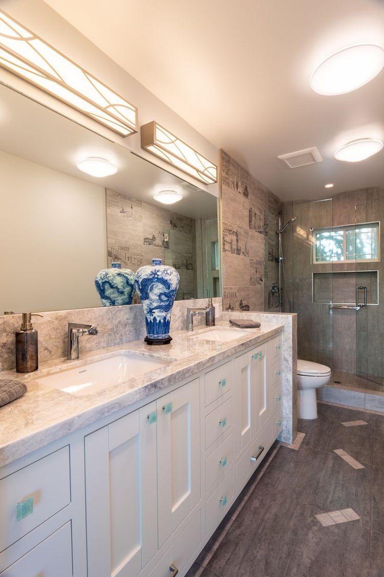 Bathroom with a double vanity in veined stone and a tiled shower by Roman Marble Shop