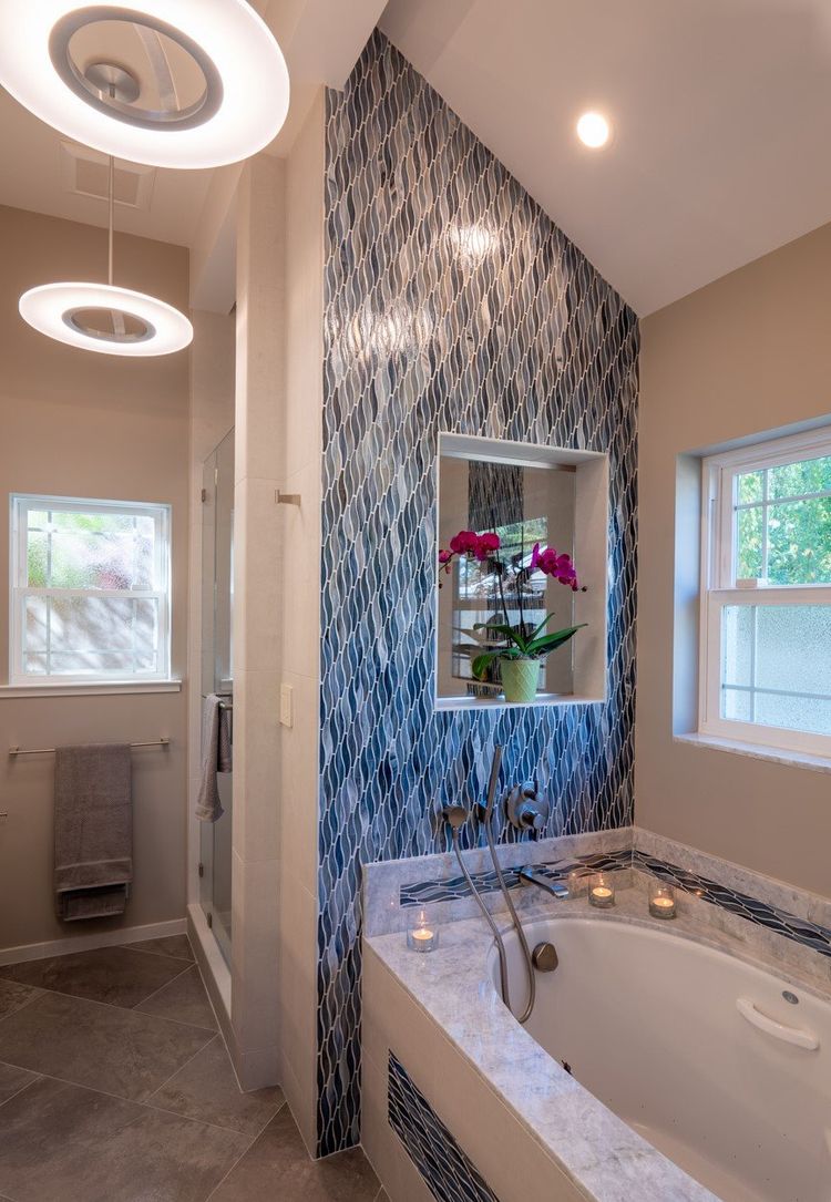 Bathroom with a marble tub deck and blue mosaic tile wall installed by Roman Marble Shop